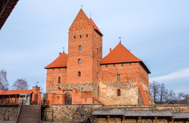 Fototapeta premium Trakai, Lithuania - February 16, 2020: Medieval gothic Island Castle with stone walls and towers with red tiled roofs. Trakai Castle is one of the most popular tourist destinations in Lithuania