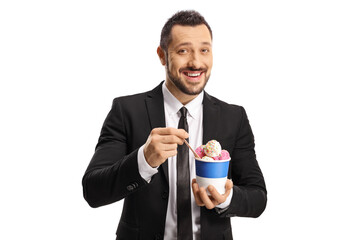 Happy young man in a suit and tie eating ice cream in a paper cup