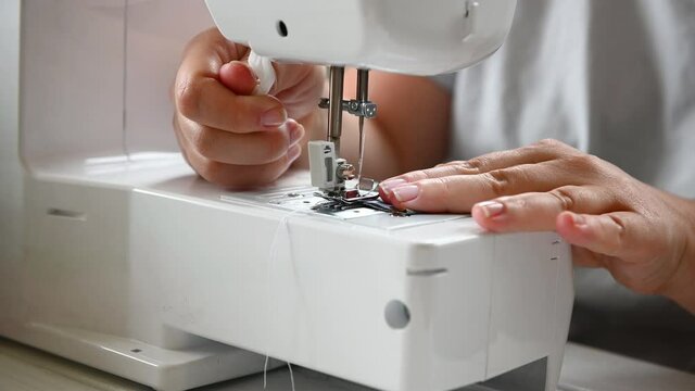 seamstress woman sews on a sewing machine close-up female hands. High quality 4k footage