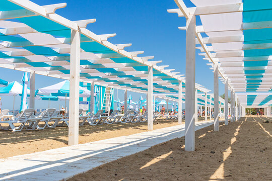 Anapa. Krasnodar Region - May 14, 2021: canopies, gazebos, painted in stripes of blue and white, architectural structures made of wood on the Black Sea beach
