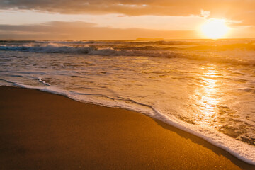 Sunrise on a Brazilian beach with waves touching the sands of the beach in Garopaba - SC