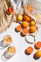 Foto op Plexiglas Summer fashion flat lay on white background. Holiday party, vacation, travel, tropical concept. Straw hat, refreshing drinks and citrus fruits. Palm shadow and sunlight, sun. Top view. © magic_cinema