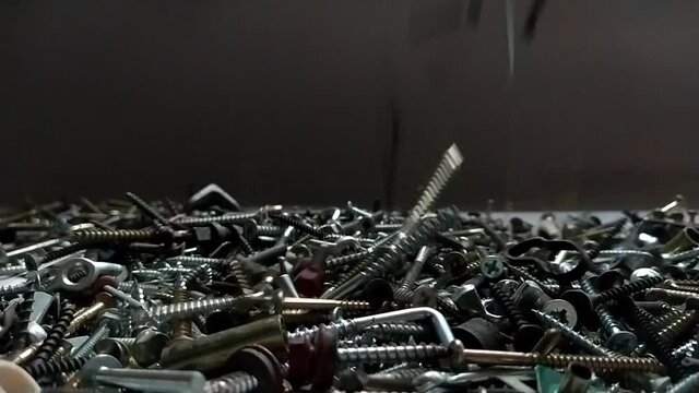 Recycle metal waste building material. Bolts, screws, nails in slow motion
