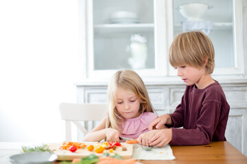 Family preparing a healthy meal in the kitchen at mediterranean home.
