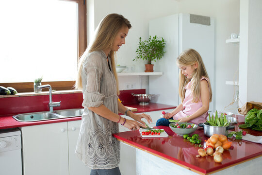 Mother and daughter preparing a dinner of vegetables