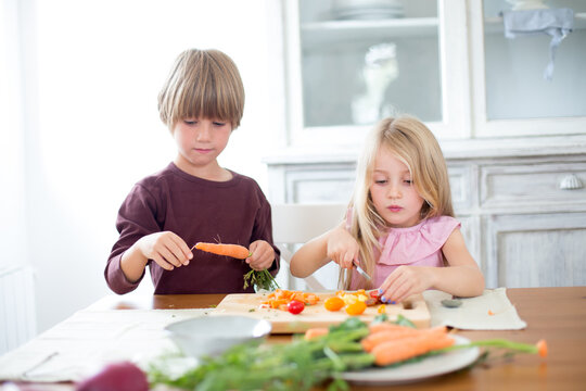 Family preparing a healthy meal in the kitchen at mediterranean home.
