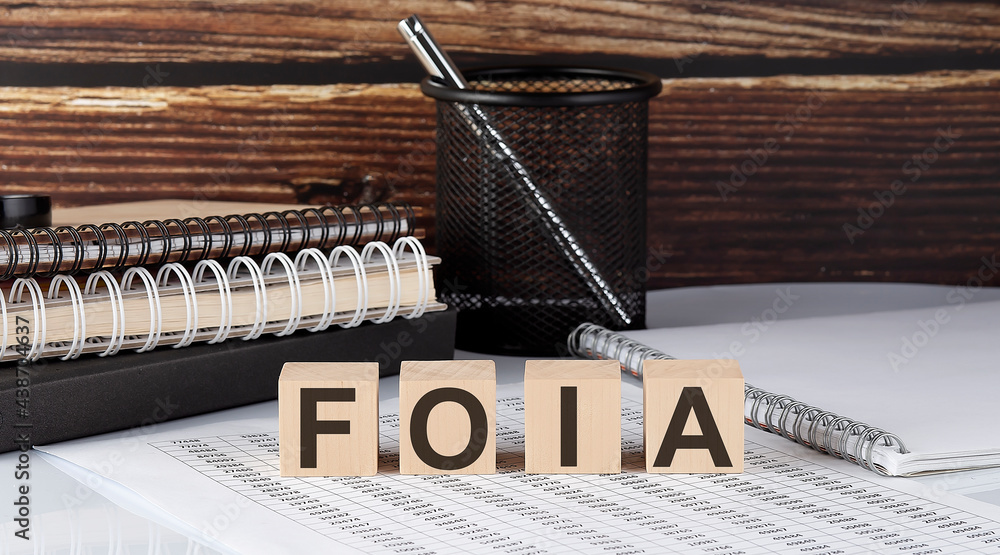 Poster foia text on the wooden block with notebooks on the chart
