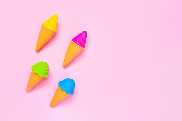 Four colorful toy ice cream on a pink background. Minimalism, summer concept