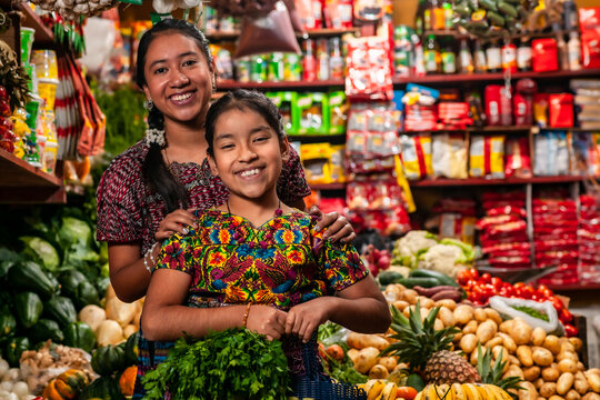 Portrait of two indigenous girls looking at the camera, in a grocery store.