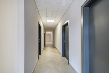 long white empty corridor in interior of entrance hall of modern apartments, office or clinic