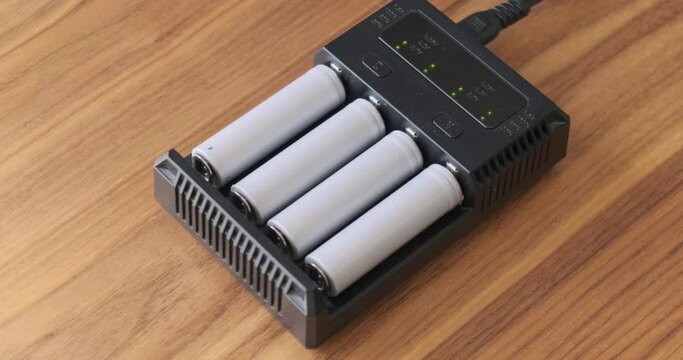 Rechargeable batteries, 18650 Li-ion type, charging in charger with blinking green led.