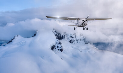 Fototapeta na wymiar Airplane flying near the Beautiful Canadian Mountain Nature Landscape. Adventure Composite. Cloudy Sunset Sky. Background from near Squamish and Vancouver, British Columbia, Canada.