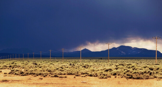 Approaching storm over the mountains and telephone poles during adventures of The West.