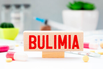 woman hand holding card with the text bulimia, cutting the word.