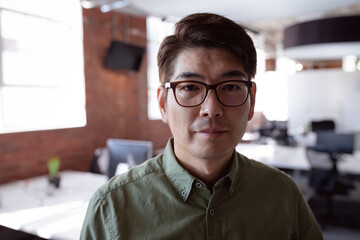 Fototapeta premium Portrait of serious asian businessman standing in office looking to camera
