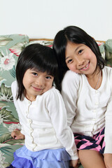 Two cute Japanese sisters smiling at the camera