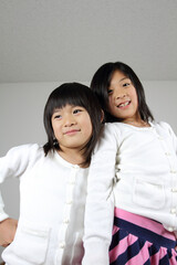 Two cute Japanese sisters smiling at the camera