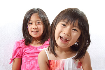 Two cute Japanese sisters smiling at the camera