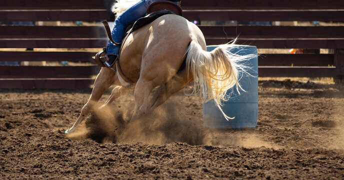 Horses and cowboys at the rodeo with fast moving racing and dirt flying.
