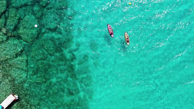 Overhead view of two kayaks near rocky coast