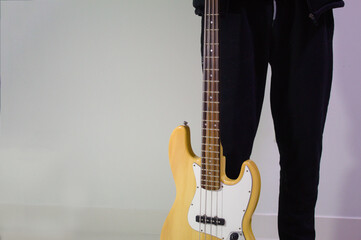young man bass player holding his musical instrument, bass guitar playing time background close-up copy space. bass stand