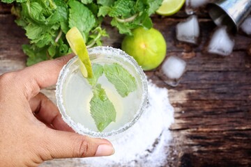 Making a margarita cocktail lime salt and mint leaves