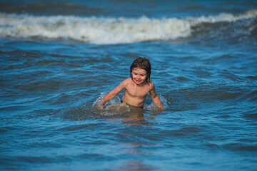 Travel lifestyle, swimming on sea summer camp. Funny kids playing on ocean beach.