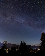 Fototapeta na wymiar Milky Way with starry night sky over town