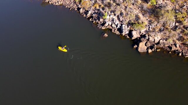 Aerial view woman on yellow kayak on Bulshoekdam Dam, Western Cape, South Africa.