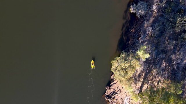 Aerial view woman on yellow kayak on Bulshoekdam Dam, Western Cape, South Africa.