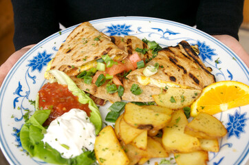 Quesadilla with home fries at diner type restaurant.