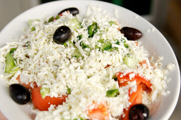 Greek salad with feta cheese, black olives, cucumber, and tomato.
