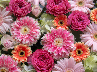 Flower arrangement of pink and orange gerberas, roses and hydrangeas.