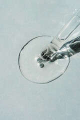 A cosmetic product flows out of a pipette with bubbles.
