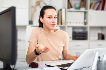 Portrait of a young female business manager working in the office of a large company at a computer