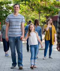 Obraz premium .Cheerful father with little glad daughter walking in the park