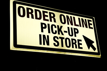 Order online pick-up in store sign illuminated at night