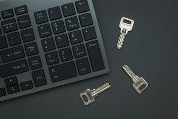Three metal keys near the computer keyboard. Flat lay.