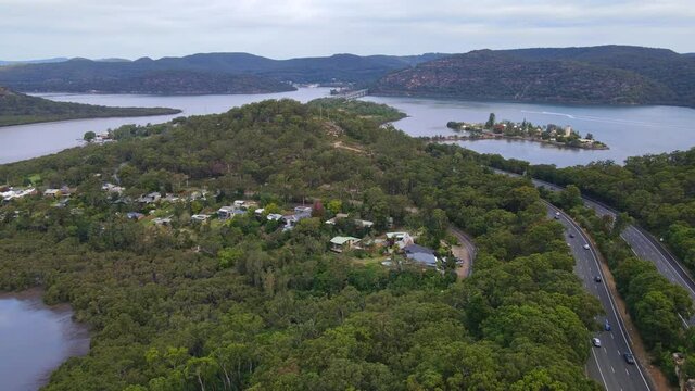 Vehicles Driving In Pacific Motorway In Mooney Mooney With A View Of Peat Island In Hawkesbury River, NSW, Australia. - aerial