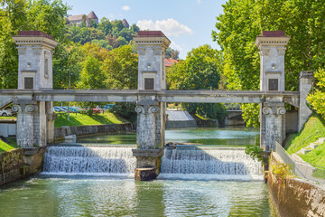 Fototapeta na wymiar The Ljubljanica River Barrier and the city castle at the background in Ljubljana, Slovenia.