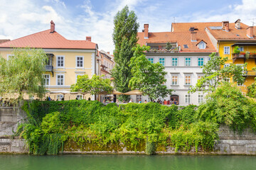 Old buildings and green vegetation in riverfront of Ljubljanica river in downtown Ljubljana, Slovenia