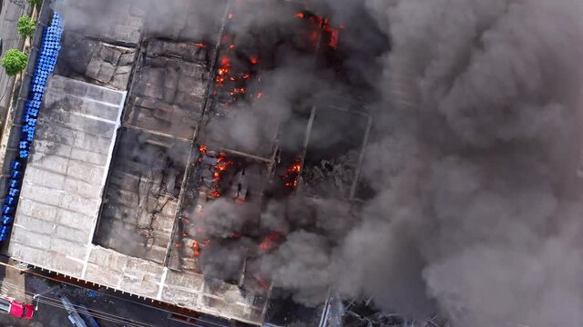 Aerial view above a factory fire, smoke in a city - screwdriver, drone shot