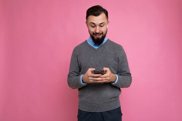 Photo shot of surprised cool good looking brunet unshaven young man with beard wearing grey sweater...