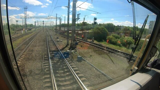 View from the locomotive driver's cab. Railway transport on the route. The train goes through the industrial area of the city.