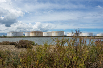 Oil tanks in a row under blue sky, Large white industrial tank for petrol, oil refinery plant. Energy and power