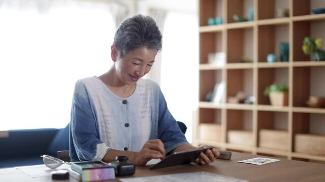 タブレットPCを見る日本人シニア女性