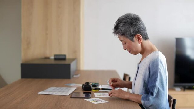 葉書に判子を押す日本人シニア女性
