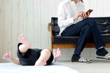 泣き叫ぶ赤ちゃんを無視してスマホを使う母親