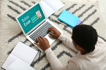 African-American with laptop passing exams online at home