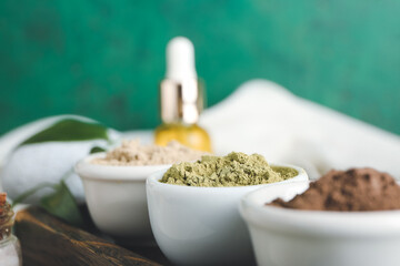 Dry henna powder in bowls on color background, closeup